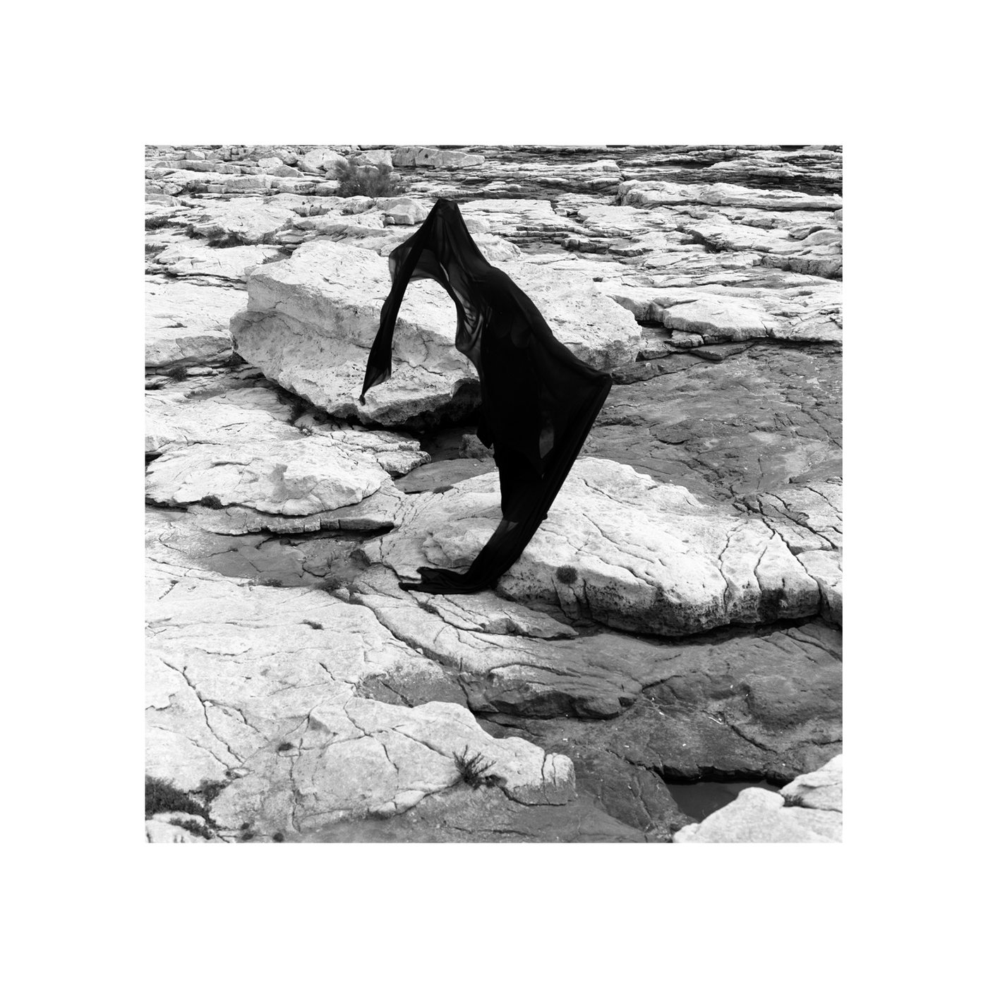 Echoes of Silence 01, a black veil-like figure moving over pale rock.