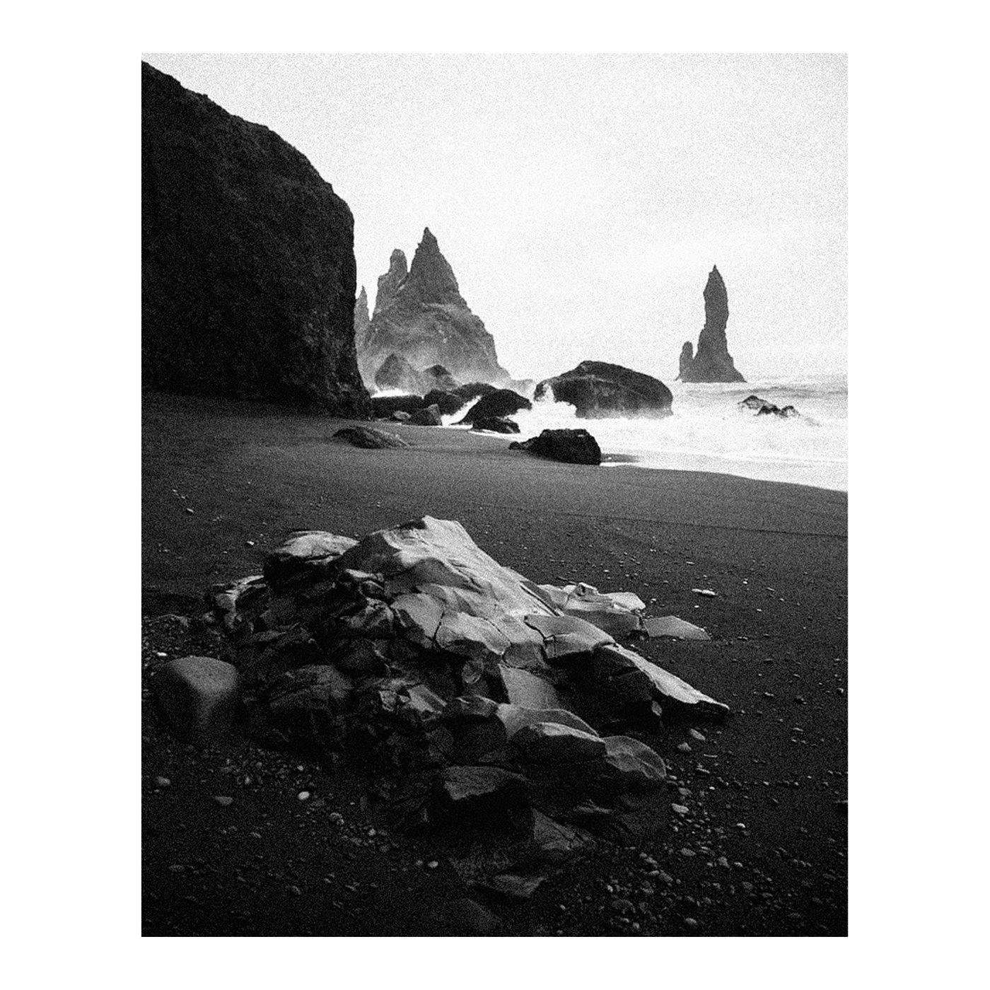Strong on the Broken Places, a black-and-white coastline with dark rocks and sea stacks.